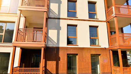 New apartment building. Residential area with modern apartment building. in sunny day. Fragments of the wooden facade.の写真素材