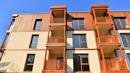 New apartment building. Residential area with modern apartment building. in sunny day. Fragments of the wooden facade.の写真素材