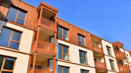 New apartment building. Residential area with modern apartment building. in sunny day. Fragments of the wooden facade.の写真素材