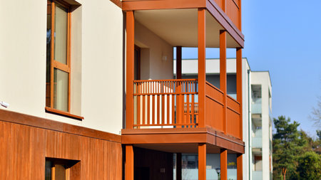 New apartment building. Residential area with modern apartment building. in sunny day. Fragments of the wooden facade.の写真素材