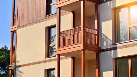 New apartment building. Residential area with modern apartment building. in sunny day. Fragments of the wooden facade.の写真素材