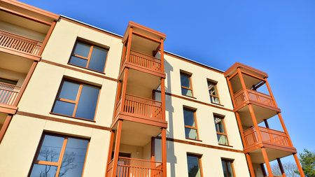 New apartment building. Residential area with modern apartment building. in sunny day. Fragments of the wooden facade.の写真素材