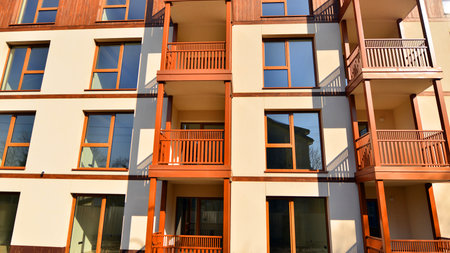 New apartment building. Residential area with modern apartment building. in sunny day. Fragments of the wooden facade.の写真素材