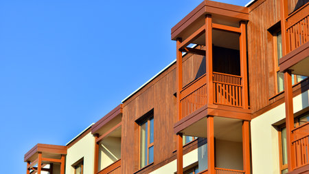 New apartment building. Residential area with modern apartment building. in sunny day. Fragments of the wooden facade.の写真素材