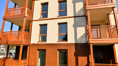 New apartment building. Residential area with modern apartment building. in sunny day. Fragments of the wooden facade.の写真素材