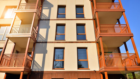 New apartment building. Residential area with modern apartment building. in sunny day. Fragments of the wooden facade.の写真素材