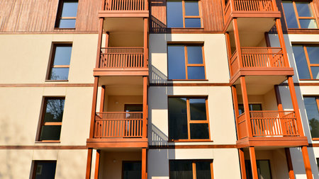 New apartment building. Residential area with modern apartment building. in sunny day. Fragments of the wooden facade.の写真素材