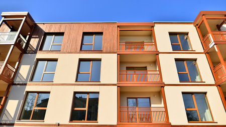 New apartment building. Residential area with modern apartment building. in sunny day. Fragments of the wooden facade.の写真素材