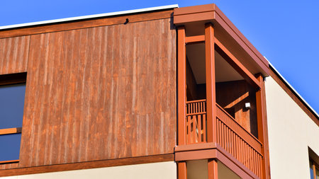New apartment building. Residential area with modern apartment building. in sunny day. Fragments of the wooden facade.の写真素材