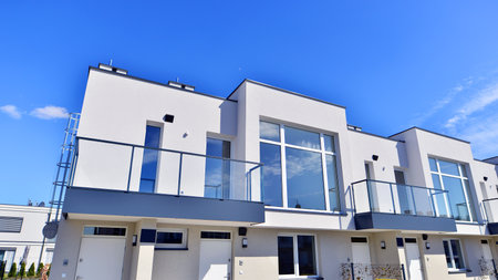 Terraced family homes in newly developed housing estate. The real estate market in the suburbs. New single family houses in a new development area. Residential homes with modern faの写真素材