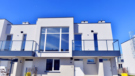 Terraced family homes in newly developed housing estate. The real estate market in the suburbs. New single family houses in a new development area. Residential homes with modern faの写真素材