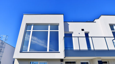 Terraced family homes in newly developed housing estate. The real estate market in the suburbs. New single family houses in a new development area. Residential homes with modern faの写真素材