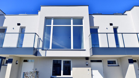 Terraced family homes in newly developed housing estate. The real estate market in the suburbs. New single family houses in a new development area. Residential homes with modern faの写真素材