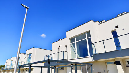 Terraced family homes in newly developed housing estate. The real estate market in the suburbs. New single family houses in a new development area. Residential homes with modern faの写真素材