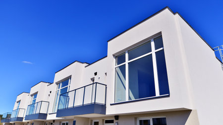 Terraced family homes in newly developed housing estate. The real estate market in the suburbs. New single family houses in a new development area. Residential homes with modern faの写真素材
