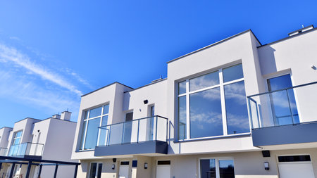 Terraced family homes in newly developed housing estate. The real estate market in the suburbs. New single family houses in a new development area. Residential homes with modern faの写真素材