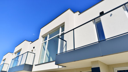 Terraced family homes in newly developed housing estate. The real estate market in the suburbs. New single family houses in a new development area. Residential homes with modern faの写真素材