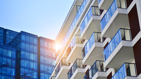 View of an modern apartment building standing next to a new modern office building with a glass facade.の写真素材