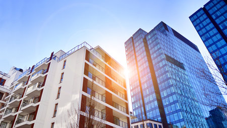View of an modern apartment building standing next to a new modern office building with a glass facade.の写真素材