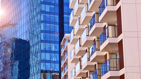 View of an modern apartment building standing next to a new modern office building with a glass facade.の写真素材
