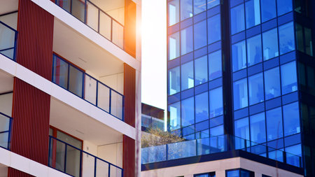 View of an modern apartment building standing next to a new modern office building with a glass facade.の写真素材
