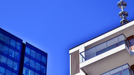 View of an modern apartment building standing next to a new modern office building with a glass facade.の写真素材