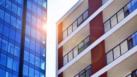 View of an modern apartment building standing next to a new modern office building with a glass facade.の写真素材