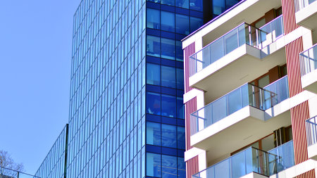 View of an modern apartment building standing next to a new modern office building with a glass facade.の写真素材