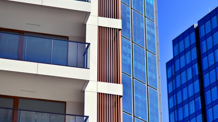 View of an modern apartment building standing next to a new modern office building with a glass facade.の写真素材