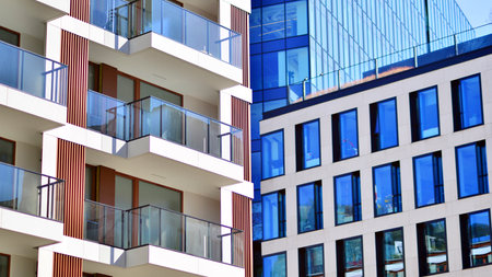View of an modern apartment building standing next to a new modern office building with a glass facade.の写真素材