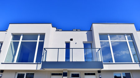 Terraced family homes in newly developed housing estate. The real estate market in the suburbs. New single family houses in a new development area. Residential homes with modern faの写真素材