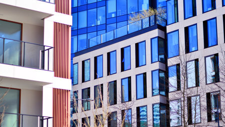 View of an modern apartment building standing next to a new modern office building with a glass facade.の写真素材