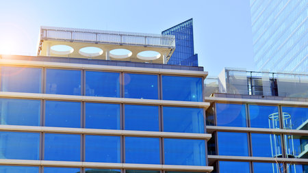 Downtown corporate business district architecture. Glass reflective office buildings against blue sky and sun light. Economy, finance, business activity concept. Rising sun on theの写真素材