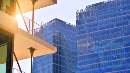 Downtown corporate business district architecture. Glass reflective office buildings against blue sky and sun light. Economy, finance, business activity concept. Rising sun on theの写真素材