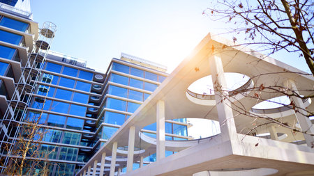 Downtown corporate business district architecture. Glass reflective office buildings against blue sky and sun light. Economy, finance, business activity concept. Rising sun on theの写真素材