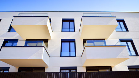Modern architecture of urban residential apartment buildings on a sunny day. Low-rise apartment buildings with large windows and extensive terraces. White facade of a modern apartmentの写真素材