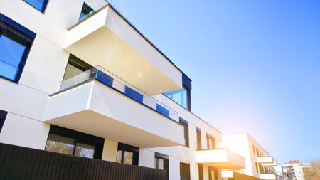 Modern architecture of urban residential apartment buildings on a sunny day. Low-rise apartment buildings with large windows and extensive terraces. White facade of a modern apartmentの写真素材