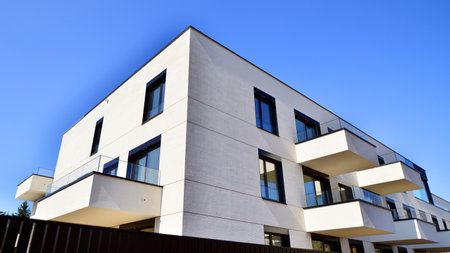 Modern architecture of urban residential apartment buildings on a sunny day. Low-rise apartment buildings with large windows and extensive terraces. White facade of a modern apartmentの写真素材