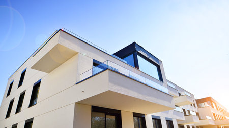 Modern architecture of urban residential apartment buildings on a sunny day. Low-rise apartment buildings with large windows and extensive terraces. White facade of a modern apartmentの写真素材