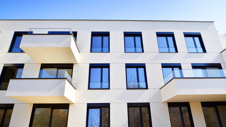 Modern architecture of urban residential apartment buildings on a sunny day. Low-rise apartment buildings with large windows and extensive terraces. White facade of a modern apartmentの写真素材