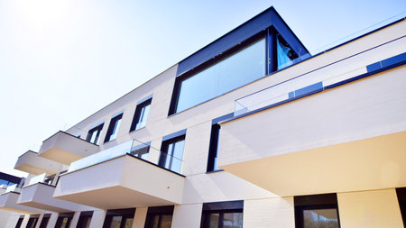 Modern architecture of urban residential apartment buildings on a sunny day. Low-rise apartment buildings with large windows and extensive terraces. White facade of a modern apartmentの写真素材