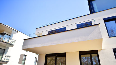 Modern architecture of urban residential apartment buildings on a sunny day. Low-rise apartment buildings with large windows and extensive terraces. White facade of a modern apartmentの写真素材