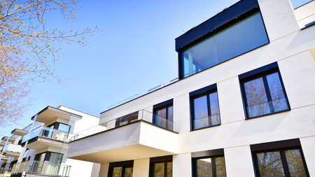 Modern architecture of urban residential apartment buildings on a sunny day. Low-rise apartment buildings with large windows and extensive terraces. White facade of a modern apartmentの写真素材