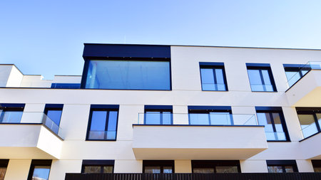 Modern architecture of urban residential apartment buildings on a sunny day. Low-rise apartment buildings with large windows and extensive terraces. White facade of a modern apartmentの写真素材