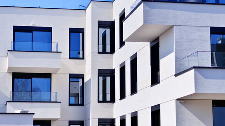 Modern architecture of urban residential apartment buildings on a sunny day. Low-rise apartment buildings with large windows and extensive terraces. White facade of a modern apartmentの写真素材