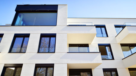 Modern architecture of urban residential apartment buildings on a sunny day. Low-rise apartment buildings with large windows and extensive terraces. White facade of a modern apartmentの写真素材