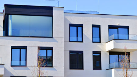 Modern architecture of urban residential apartment buildings on a sunny day. Low-rise apartment buildings with large windows and extensive terraces. White facade of a modern apartmentの写真素材