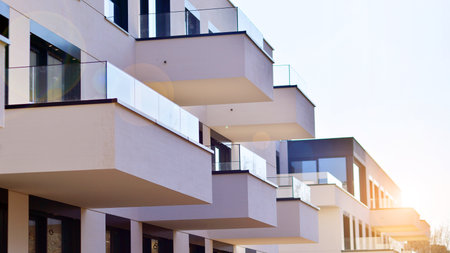 Modern architecture of urban residential apartment buildings on a sunny day. Low-rise apartment buildings with large windows and extensive terraces. White facade of a modern apartmentの写真素材