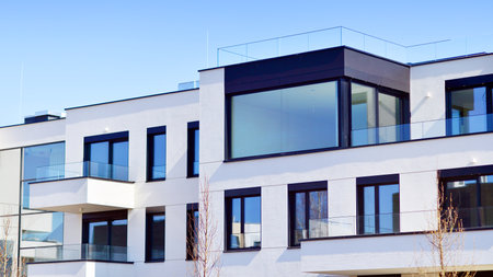 Modern architecture of urban residential apartment buildings on a sunny day. Low-rise apartment buildings with large windows and extensive terraces. White facade of a modern apartmentの写真素材