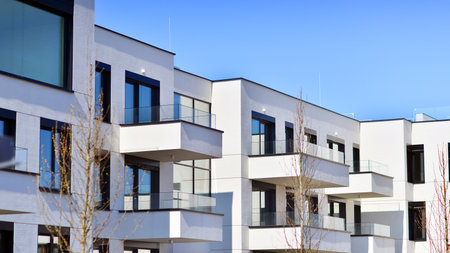 Modern architecture of urban residential apartment buildings on a sunny day. Low-rise apartment buildings with large windows and extensive terraces. White facade of a modern apartmentの写真素材